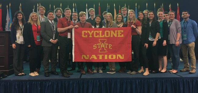 Iowa State University students holding up a "Cyclone Nation" red flag.